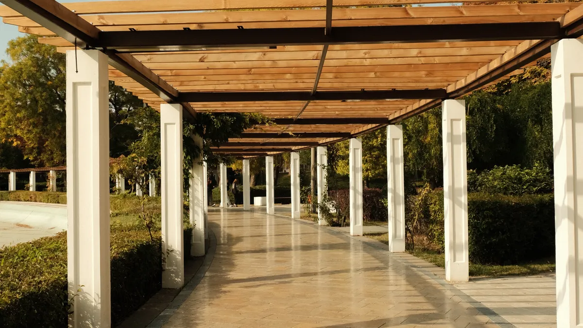 How to Maintain a Wooden Pergola Year Round How to Maintain a Wooden Pergola Year Round — Sunny Wooden Pergola Walkway in Park Setting