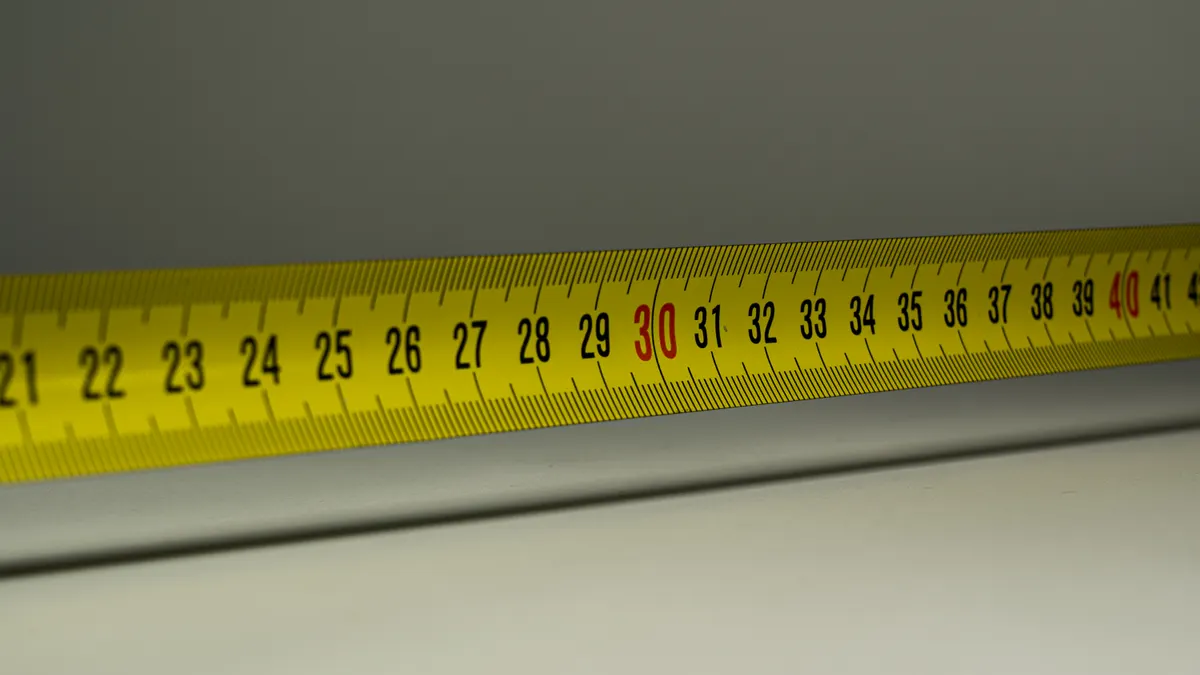 How to Measure for a Pergola Opening Before You Buy or Build Close-up tape measure along a wall edge