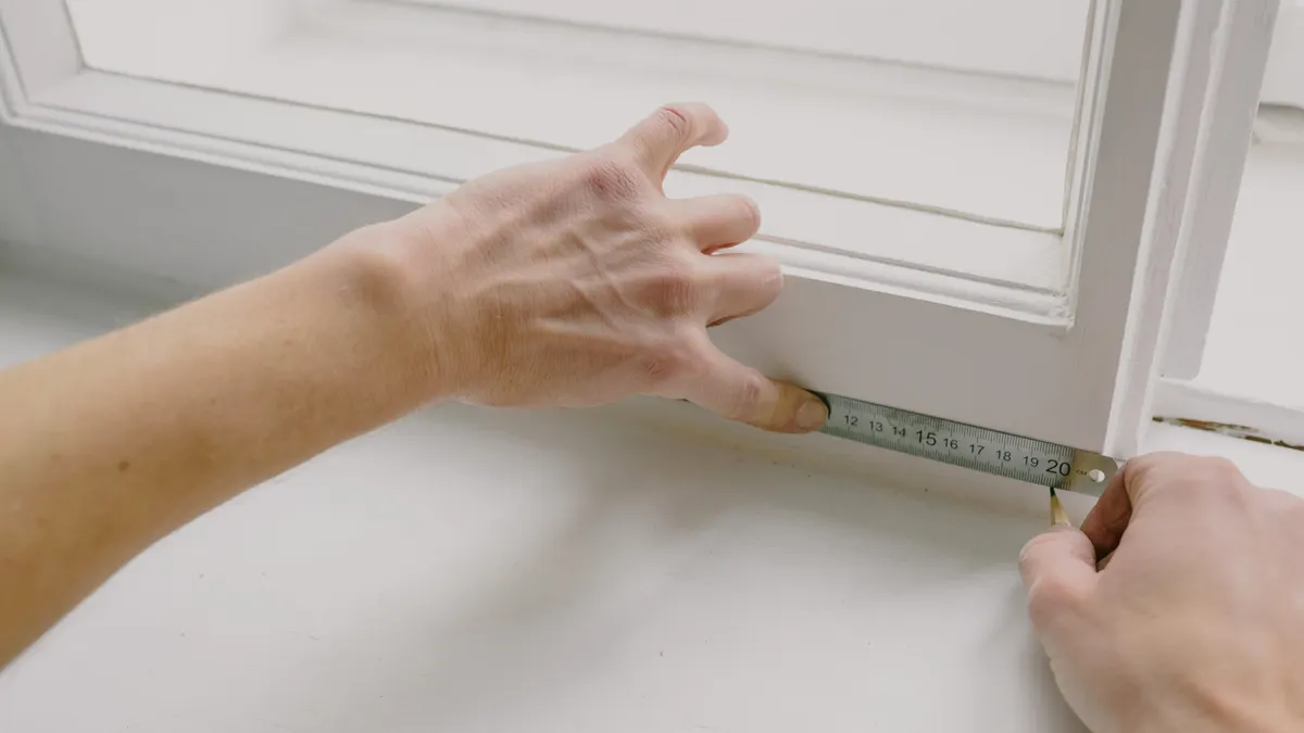 How to Measure for a Pergola Opening Before You Buy or Build Hands measuring a window or door opening
