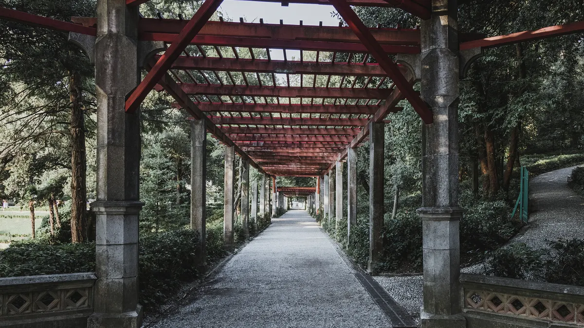 Pergola Beam and Rafter Layout Patterns: Spacing, Orientation, and Look Long walkway framed by repeated pergola beams